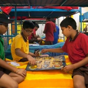 Boys playing a board game on a bunk bed