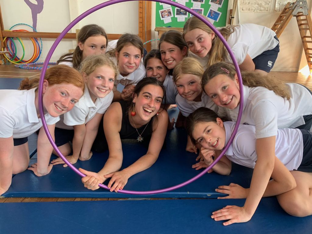 group of students smiling through a hula hoop