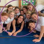 group of students smiling through a hula hoop